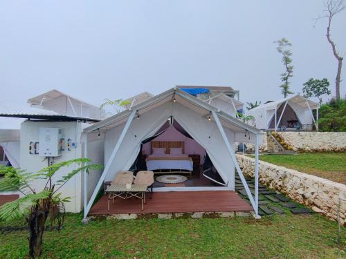tenda con letto e 2 sedie in cortile di HappyNest Glamping and Villa Dieng a Garung