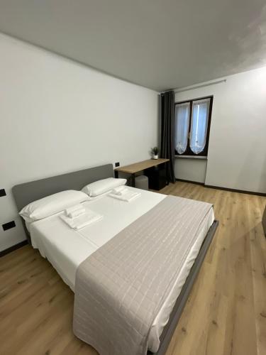 a bedroom with a large white bed and a table at I Bastioni Rooms in Peschiera del Garda