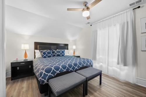 a bedroom with a bed with a blue comforter and a window at 2nd-Floor Retreat in Vibrant Detroit 2 Bedroom in Detroit