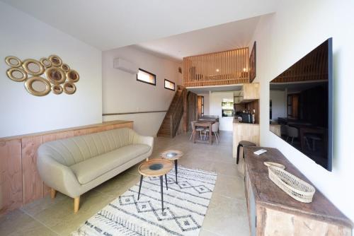 un salon avec un canapé et une table dans l'établissement Maison du Lac, en bord de canal à Cazaux, à La Teste-de-Buch