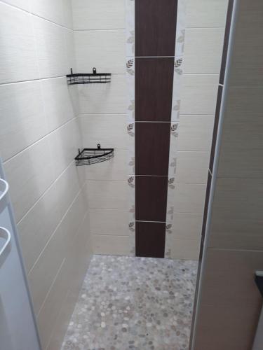 a walk in shower with white walls and shelves at Gîte chez Marie et Franck in Barbaste
