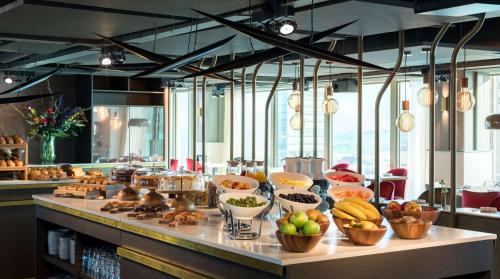 a buffet line with bowls of fruits and vegetables at NH Collection Eindhoven Centre in Eindhoven