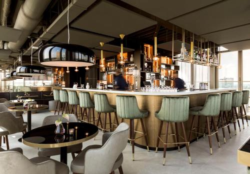 a bar in a restaurant with chairs and tables at NH Collection Eindhoven Centre in Eindhoven