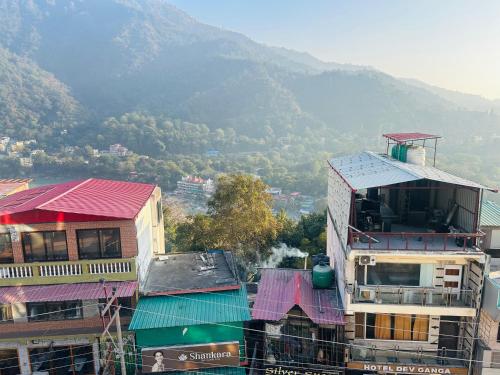 una vista di una città con le montagne sullo sfondo di Shubhra Home Stay And Restaurant a Rishikesh