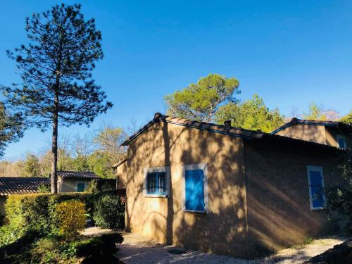 une petite maison avec un arbre en face dans l'établissement Provence, Uzès, Gaujac maisonnette 6-7 personnes dans résidence, à Gaujac