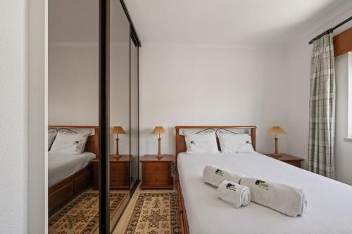 a bedroom with two beds and a mirror at BmyGuest - Sesimbra Central Apartment in Sesimbra