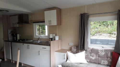 a small kitchen with a couch and a window at Ferienhaus 2 Chalet in Ahrbrück