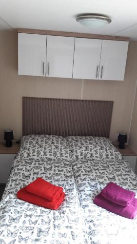 a bed with two red pillows on top of it at Ferienhaus 2 Chalet in Ahrbrück
