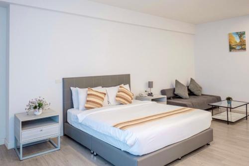 a bedroom with a large bed and a couch at GRAND PA Hotel&Resort Lamphun Chiang Mai in Lamphun