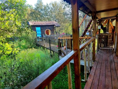 a wooden walkway to a cabin with a dog house at GITES O FIL DE L'EAU piscine spa accès rivière in Omessa
