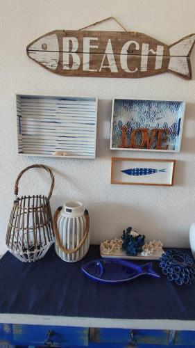 a table with plates and a fish sign on a wall at Amanecer en Cristal in Cartagena