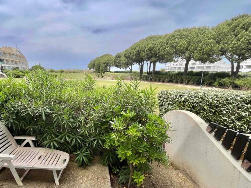 quelques chaises assises à côté de quelques buissons dans l'établissement Port Camargue : Appartement 4 personnes, plage & jardin, parking privatif - FR-1-716-87, au Grau-du-Roi