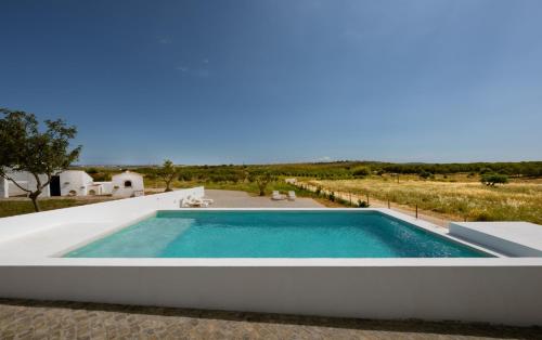 a swimming pool in the middle of a house at Aroucas Turismo e Natureza in Castro Marim