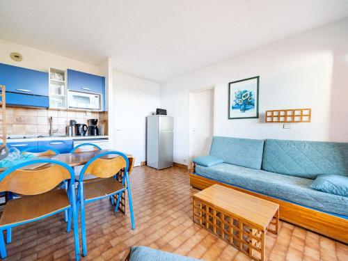 un salon avec un canapé bleu et une table dans l'établissement Appartement 8 personnes avec kitchenette équipée et Wi-Fi - FR-1-827-3, à Roquebrune-Cap-Martin