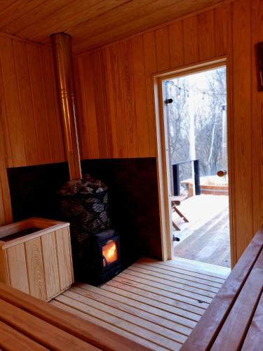 a room with a wood stove in a cabin at Casuta Sofiei in Vîrfu Dealului