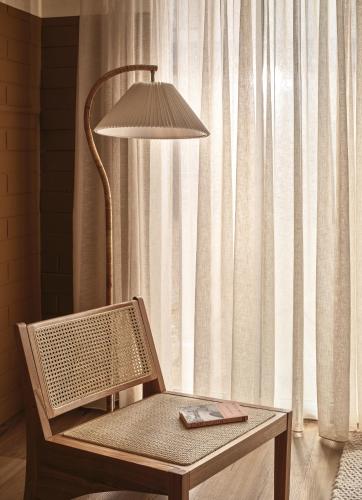 a lamp sitting next to a table with a chair at Casita Motel in Batehaven