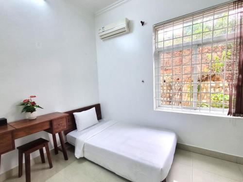 a room with a bed and a desk and a window at Top Hill Halong in Ha Long