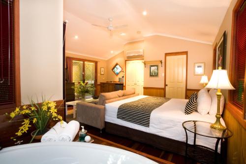ein Hotelzimmer mit einem Bett und einer Badewanne in der Unterkunft Amore On Buderim Rainforest Cabins in Buderim