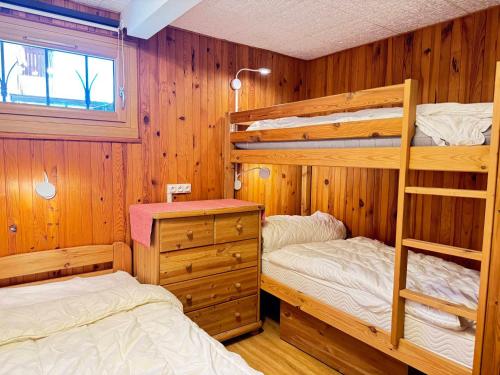 Ce lit se trouve dans un dortoir doté de 2 lits superposés et de murs en bois. dans l'établissement Appartement cosy 8 pers avec terrasse, proche des pistes, Les Gets - FR-1-623-368, aux Gets