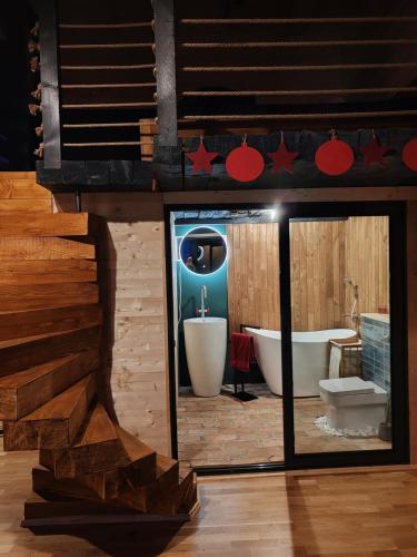 a bathroom with a bath tub and a mirror at Forest Studio Corunca in Corunca