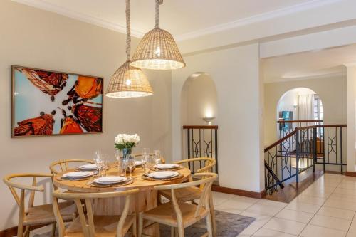 a dining room with a wooden table and chairs at Riverside Park Tropical Oasis 3B YourHost Nairobi in Nairobi