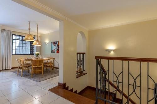 a dining room and living room with a table at Riverside Park Tropical Oasis 3B YourHost Nairobi in Nairobi