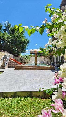 a park with stairs and a pavilion with pink flowers at Casa Idaman Motel Langkawi in Pantai Cenang