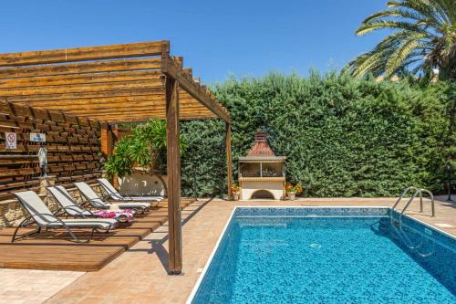 a swimming pool with chaise lounge chairs next to a swimming pool at Villa Agathi in Argaka