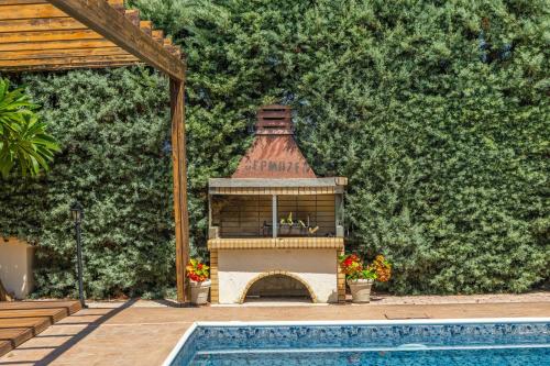 a house with a fireplace next to a swimming pool at Villa Agathi in Argaka