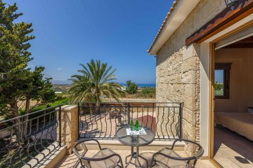 a patio with a table and chairs on a balcony at Villa Agathi in Argaka
