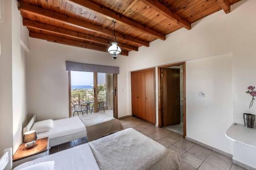 a bedroom with two beds and a balcony at Villa Agathi in Argaka