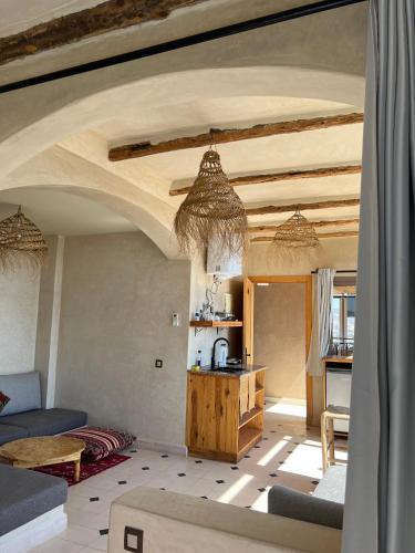 a living room with a couch and a table at SurfAppart Morocco in Tamraght Ouzdar
