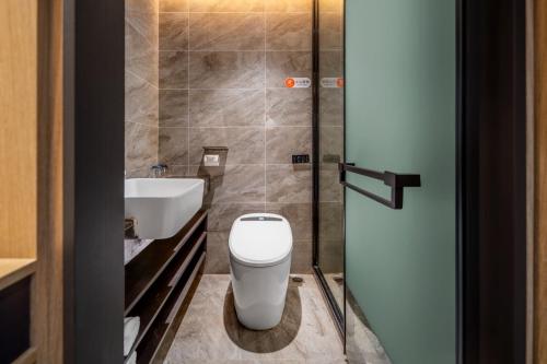 a bathroom with a toilet and a sink at Weiting Light Hotel Shanghai University of Finance and Economics in Shanghai
