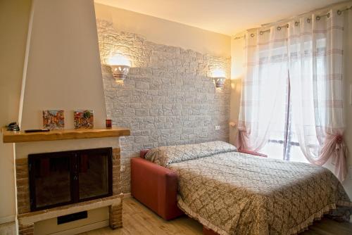 a bedroom with a bed and a fireplace at L'angolo delle More in Monte Castello di Vibio