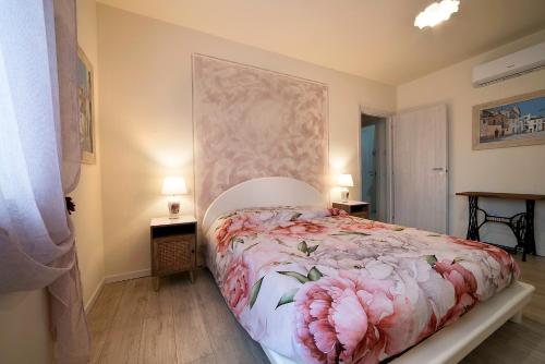 a bedroom with a bed with pink flowers on it at L'angolo delle More in Monte Castello di Vibio