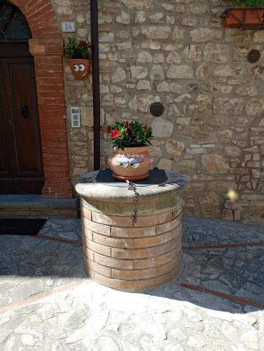a flower pot sitting on top of a brick barrel at L'angolo delle More in Monte Castello di Vibio