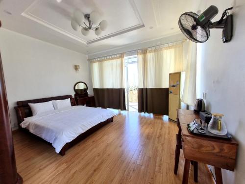 a bedroom with a bed and a desk with a fan at Top Hill Halong in Ha Long