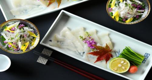 three plates of food on a table with chopsticks and vegetables at Ubusuna no Sato TOMIMOTO in Ando