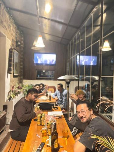 a group of men sitting at a table in a restaurant at Mellow Fellow Hostel Darjeeling in Darjeeling