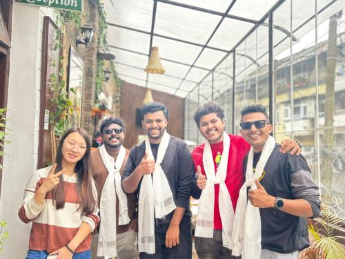 a group of people giving the thumbs up at Mellow Fellow Hostel Darjeeling in Darjeeling