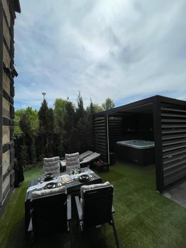 a patio with a table and chairs and a bath tub at Bahnhofsoase - Wellness & Spa am Krufter Bahnhof in Kruft
