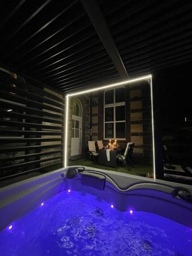a jacuzzi tub in a living room at night at Bahnhofsoase - Wellness & Spa am Krufter Bahnhof in Kruft