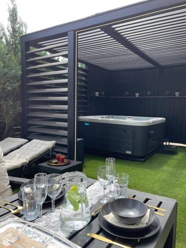 a patio with a table with glasses and a tub at Bahnhofsoase - Wellness & Spa am Krufter Bahnhof in Kruft
