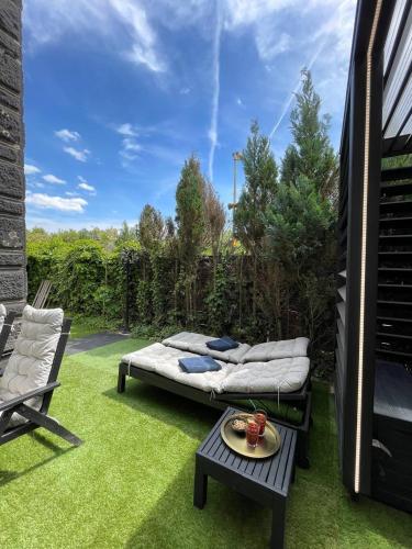 a patio with a bed and a table and a chair at Bahnhofsoase - Wellness & Spa am Krufter Bahnhof in Kruft