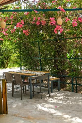 a table and chairs with pink flowers on it at Nature House in Al Ḩamrāʼ