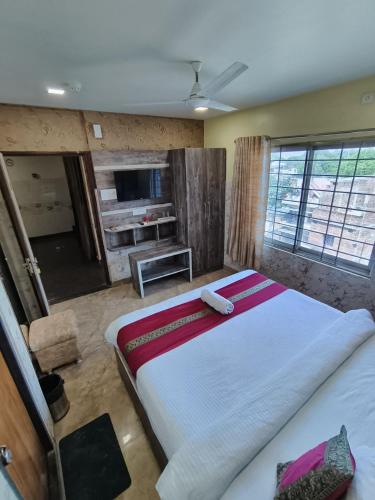 a bedroom with a large bed and a television at Hotel R S RESIDENCY in Varanasi