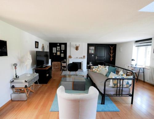 una sala de estar con un sofá y una mesa en LE COSY duplex centre ville, en Betton