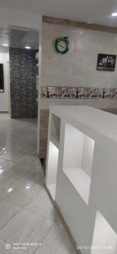 een kamer met een muur met een klok erop bij appartement T3 équipe in Matriouene