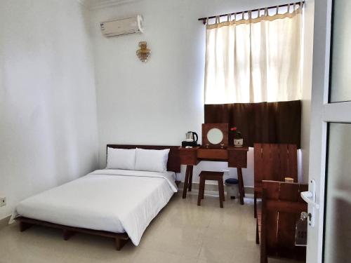 a bedroom with a bed and a desk and a window at Top Hill Halong in Ha Long
