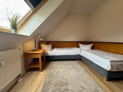 Dos camas individuales en una habitación con ventana. en Oewern Diek App 08, en Wustrow